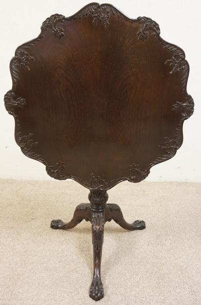 SOLID MAHOGANY TILT TOP TABLE WITH CARVED SCALLOPED: SOLID MAHOGANY TILT TOP TABLE WITH CARVED SCALLOPED EDGE OVER A REEDED COUMN WITH BALL AND CLAW FOOT BASE, 29 1/2 IN WIDE X 28 IN HIGH