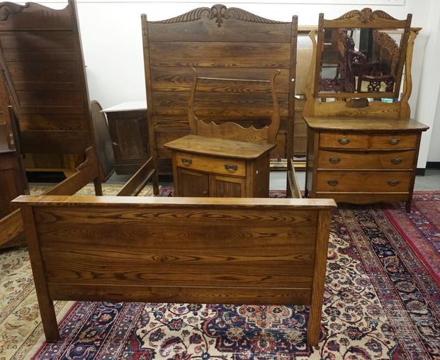 THREE PIECE CARVED OAK BEDROOM SET: THREE PIECE CARVED OAK BEDROOM SET; HIGHBACK BED, DRESSER W/ BEVELED MIRROR & WASHSTAND W/ TOWEL BAR. BED 57 1/2 IN W 72 IN H