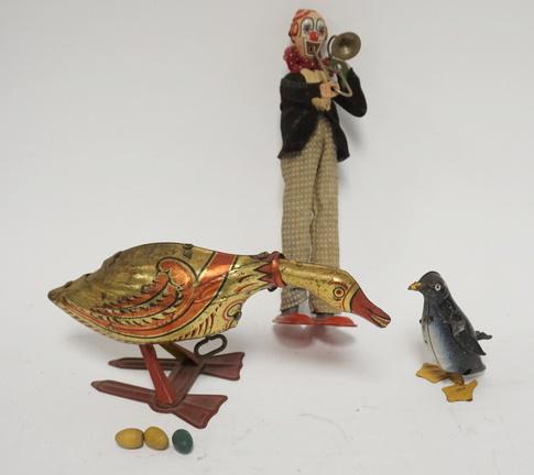 THREE TIN WIND UP TOYS: THREE TIN WIND UP TOYS; GOOSE, CLOWN & PENGUIN. GOOSE LAYS EGGS & HAS 3 EGGS. CLOWN IS 9 1/2 IN H