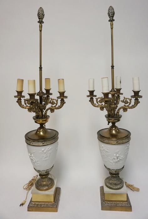 PAIR OF PARIAN URN FORM LAMPS: PAIR OF PARIAN URN FORM LAMPS, RELIEF DECORATION OF CHERUBS ON CLOUDS, BRASS MOUNTS, PINEAPPLE FINIALS, 40 1/2 IN HIGH