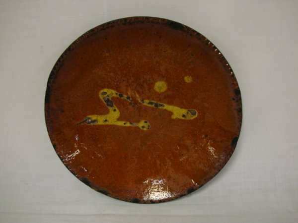 DECORATED REDWARE PIE PLATE; SOME WEAR TO THE DEC: DECORATED REDWARE PIE PLATE; SOME WEAR TO THE DECORATION; 8 3/8 IN