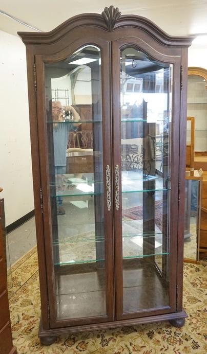 JASPER CURIO CABINET WITH CARVED ARCH TOP: JASPER CURIO CABINET WITH CARVED ARCH TOP HAS BEVELED GLASS DOORS, LIGHTING, MIRROR BACK & GLASS SHELVES. 40 1/2 IN W 81 3/4 IN H