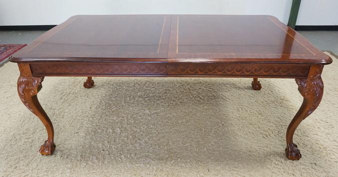 STANLEY BANDED MAHOGANY DINNING TABLE W/ CARVED SKIRT: STANLEY BANDED MAHOGANY DINNING TABLE W/ CARVED SKIRT & BALL & CLAW FEET HAS LEAF CARVED KNEES. IT HAS TWO 24 IN SKIRTED LEAVES. 46 IN X 76 IN CLOSED