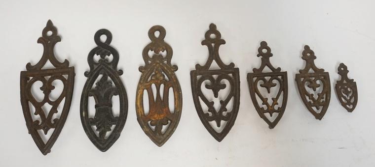 7 CAST IRON SMALL TRIVETS: SEVEN CAST IRON SMALL TRIVETS. LARGEST IS 6 IN, SMALLEST IS 2 1/4 IN