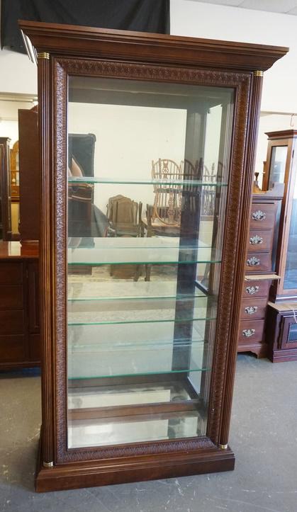 LARGE LIGHTED DISPLAY CABINET: LARGE LIGHTED DISPLAY CABINET SIDE LOADER HAS MIRROR BACK, GLASS SHELVES, CARVING AROUND THE BEVELED GLASS FRONT & REEDED HALF COLUMNS W/ BRASS TRIM. 42 IN W 80 IN H 15 IN DEEP, SOME VENEER LOSS ON TO