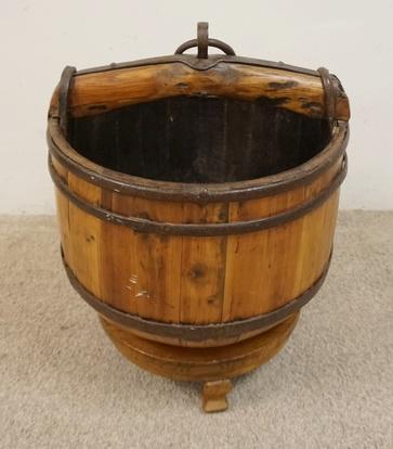 UNUSUAL WOODEN STAVE BUCKETT ON STAND: UNUSUAL WOODEN STAVE BUCKETT ON STAND W/OX YOKE STYLE HANDLE, WROUGHT IRON SIDES & TAPERED FUNNEL BASE, 19 IN WIDE X 24 IN