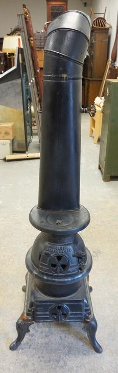 CAST IRON STOVE SEARS, ROEBUCK & CO: CAST IRON STOVE SEARS, ROEBUCK & CO, 57 1/2 IN HIGH TO TOP OF PIPE, BASE AT FEET IS 18 IN X 16 1/2 IN