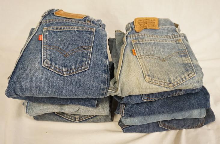 LOT OF 10 PAIRS OF VINTAGE LEVIS JEANS: LOT OF TEN PAIRS OF VINTAGE LEVI STRAUSS & COMPANY JEANS W/ RED & ORANGE TABS, VARYING DEGREE OF WEAR. TWO SIZES ARE UNKNOWN. THEY MEASURE APPROXIMATELY 22 IN W & 27 IN W. THE YOUTH SIZES ARE 14, 12, 