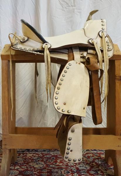 WHITE WESTERN SADDLE: WHITE WESTERN SADDLE WITH METAL HORN MEASURES FROM HORN TO EDGE OF SEAT APPROXIMATELY 15 1/2 IN