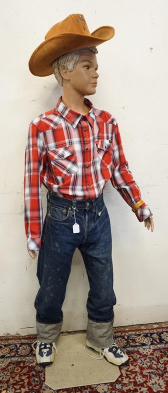 BOY MANNEQUIN CLOTHED IN VINTAGE SELVEDGE LEVIS JEANS: BOY MANNEQUIN CLOTHED IN VINTAGE LEVIS SELVEDGE JEANS, SNEAKERS, CURRENT SHIRT, & COWBOY HAT. APP. 60 IN TALL. MANNEQUIN MAY SUFFER LOSSES TO BODY/FACE
