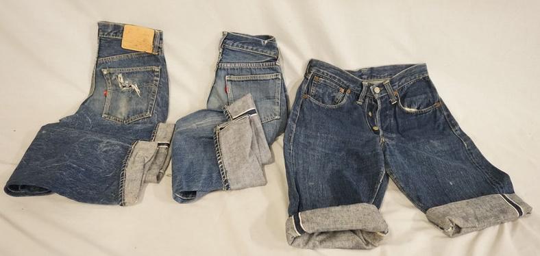 LOT OF 3 PAIRS OF VINTAGE LEVIS SELVEDGE JEANS: LOT OF THREE PAIRS OF VINTAGE LEVIS SELVEDGE JEANS. ONE PAIR HAS BEEN CUT INTO SHORTS WAIST MEASURES APP. 27 IN. ONE PAIR IS MARKED SIZE 27 X 30 THE LAST PAIR THE WAIST MEASURES APP. 24 IN REVERSE OF 