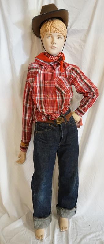 BOY MANNEQUIN CLOTHED IN VINTAGE LEVIS SELVEDGE JEANS: BOY MANNEQUIN CLOTHED IN VINTAGE LEVIS SELVEDGE JEANS W/ BIG E, BELT W/ LEVIS BELT BUCKLE, LEVIS SHIRT, BANDANNA & A COWBOY HAT. APP. 60 IN TALL. MANNEQUIN MAY SUFFER LOSSES TO BODY/FACE