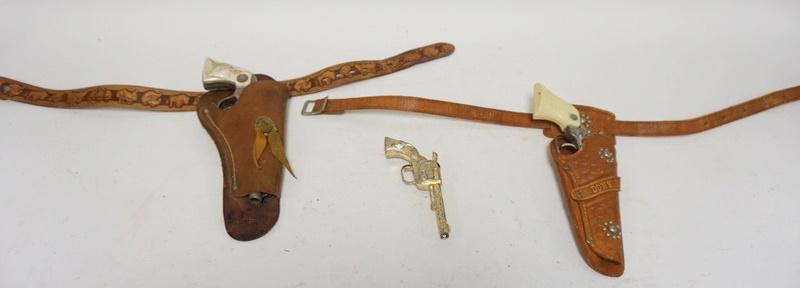 GROUP OF 3 ANTIQUE TOY CAP GUNS: GROUP OF 3 ANTIQUE TOY CAP GUNS, 2 IN HOLSTERS, 1 LEATHER BELT WITH DISNEY CHARACTERS
