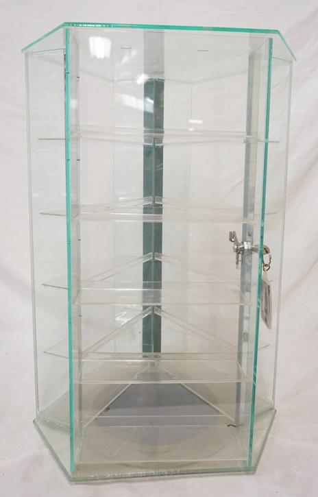 MULTI TIER PLASTIC DISPLAY CASE ON TURNTABLE: MULTI TIER PLASTIC DISPLAY CASE ON TURNTABLE HAS LOCKING DOOR W/ KEY. 25 IN X 17 1/4 IN 15 IN DEEP