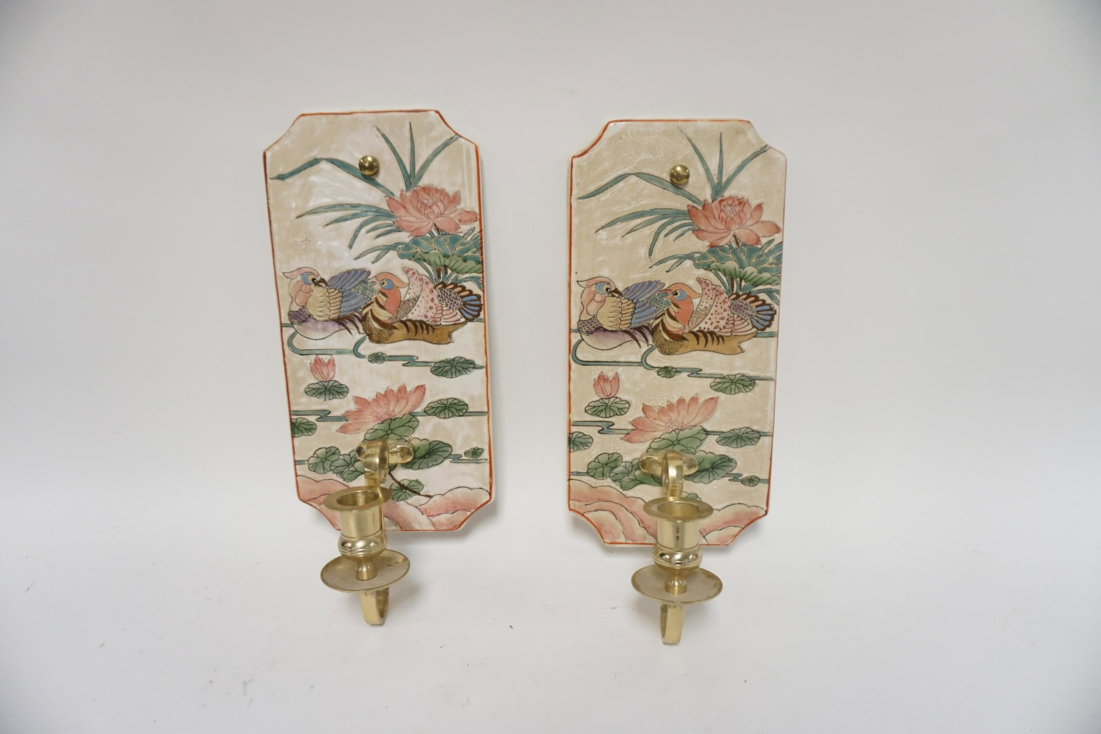 PAIR OF DECORATED POTTERY WALL CANDLE SCONCES: PAIR OF DECORATED POTTERY WALL CANDLE SCONCES W/ BRASS CANDLE HOLDERS. 13 1/2 IN H 5 1/2 IN W