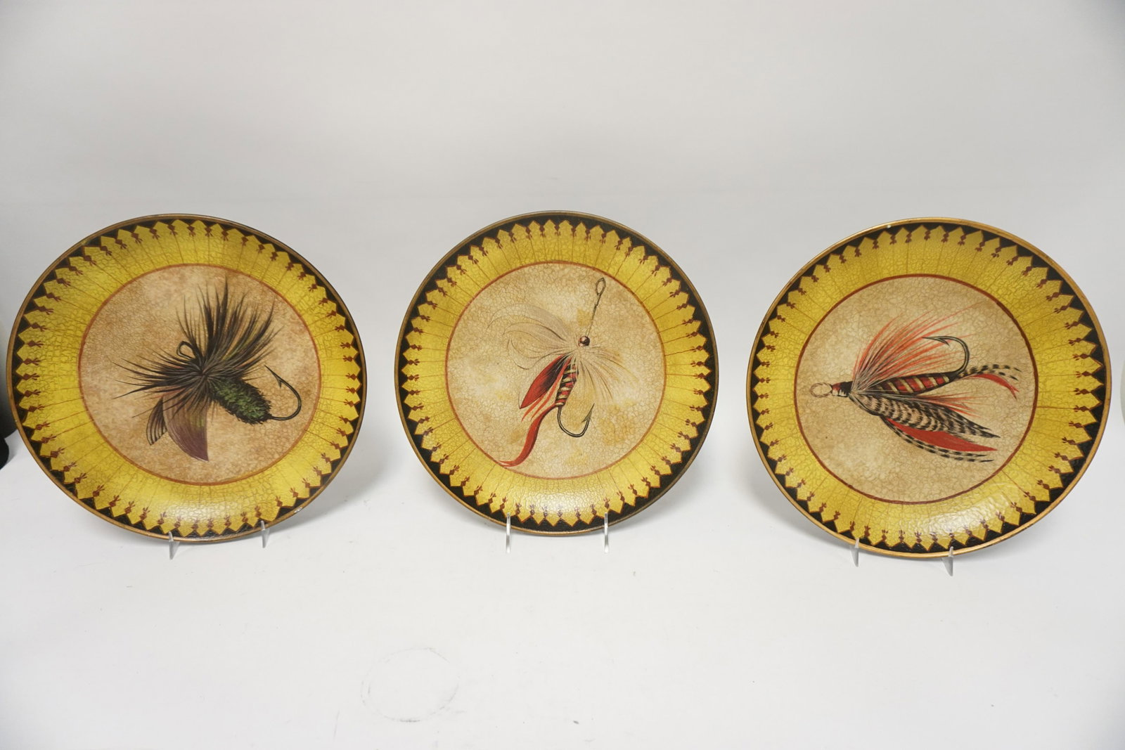 3 POTTERY PLATES W/ FLY FISHING LURE DECORATION: THREE 12 1/4 IN POTTERY PLATES W/ FLY FISHING LURE DECORATION. TWO OF THE PLATES HAVE SMALL RIM CHIPS