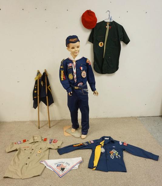 MANNEQUIN CLOTHED IN CUB SCOUTS UNIFORM & BOY SCOUTS: MANNEQUIN CLOTHED IN CUB SCOUTS UNIFORM W/ PATCHES, A BELT W/ CUB SCOUTS BELT BUCKLE A CUB SCOUTS CAP. PLUS THREE BOY SCOUTS UNIFORM SHIRTS W/ PATCHES A BOY SCOUT BERET & A PHILMONT 1976 SCARF. MANNEQ