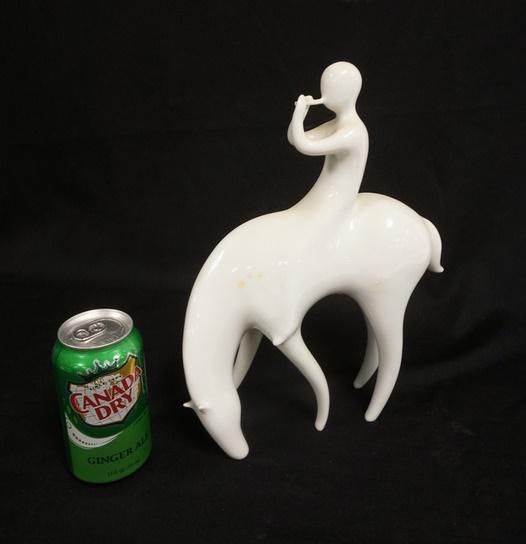 ROYAL DUX MIDCENTURY MODERN FLUTE PLAYER: ROYAL DUX MIDCENTURY MODERN FLUTE PLAYER ON HORSE, WHITE PORCELAIN, 9 IN X 12 1/2 IN HIGH