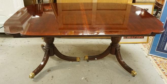 BANDED MAHOGANY DOUBLE PEDESTAL DINING TABLE: BANDED MAHOGANY DOUBLE PEDESTAL DINING TABLE, HAS BRASS FEET, CARVED LEGS & ROUNDED CORNERS, HAS 2-16 IN LEAVES, 68 IN X 44 IN CLOSED