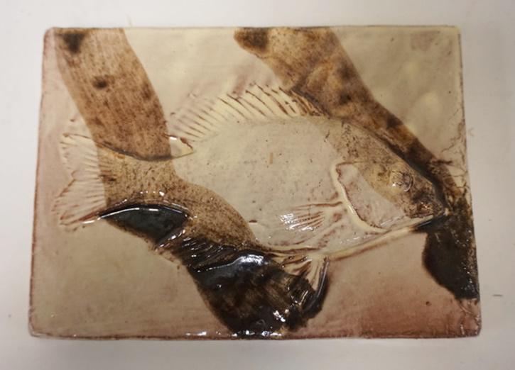 SIGNED TILE DEPICTING A FISH: SIGNED TILE DEPICTING A FISH IN RELIEF, 7 IN X 5 1/4 IN