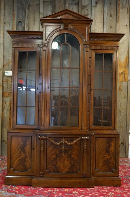 TRIPLE DOOR MAHOGANY BREAKFRONT/CHINA CABINET: TRIPLE DOOR MAHOGANY BREAKFRONT/CHINA CABINET W/BURLED DOORS ON BASE, INTERIOR LIT, GREEK KEY MOLDING BELOW PEDIMENT TOP, APPROXIMATELY 60 IN X 14 IN X 88 IN HIGH