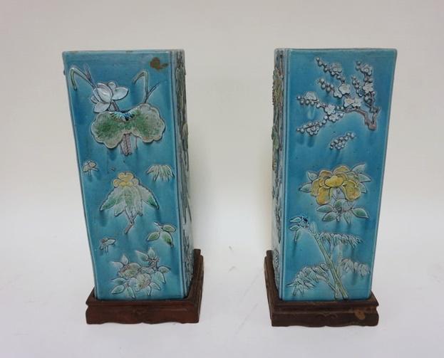 PAIR OF SQUARE POTTERY CHINESE VASES: PAIR OF SQUARE POTTERY CHINESE VASES ON WOOD BASES, CHARACTER MARKS ON BASE, RELIEF FLORAL DECORATIONS ALL AROUND, APPROXIMATELY 12 IN HIGH