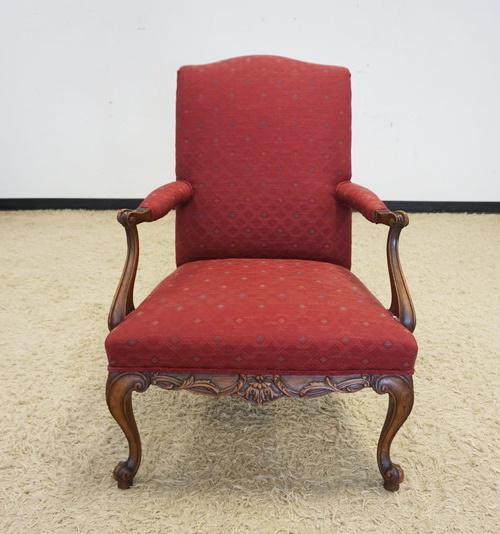 UPHOLSTERED ARM CHAIR: UPHOLSTERED ARM CHAIR WITH CARVED WALNUT SKIRT AND FRENCH PROVINCIAL LEGS