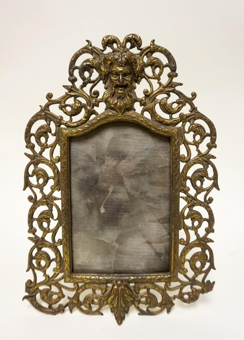 ANTIQUE VICTORIAN ORNATE BRASS FRAME: ANTIQUE VICTORIAN ORNATE BRASS FRAME W/GROTESQUE FACE AT TOP, APPROXIMATELY 14 IN HIGH