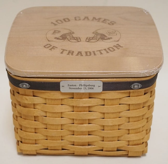 2006 EASTON PHILLIPSBURG 100 GAME BASKET: 2006 EASTON PHILLIPSBURG 100 GAMES OF TRADITION FOOTBALL BASKET WITH PROTECTOR AND LID. APPROXIMATELY 6 3/4 IN X 8 X 7 IN, NEW