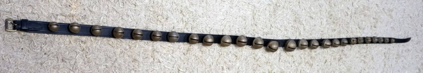 NICE STRAND OF BRASS SLEIGH BELLS: NICE STRAND OF BRASS SLEIGH BELLS ON 93 IN LEATHER STRAP, 26 GRADUATED SIZE BELLS