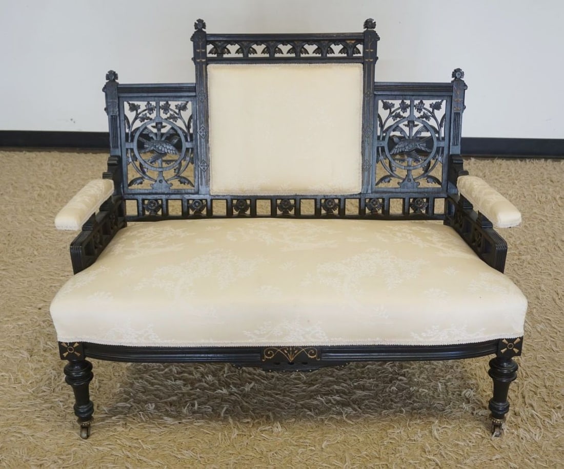 ORNATE EASTLAKE VICTORIAN SETTEE: ORNATE EASTLAKE VICTORIAN UPHOLSTERED PARLOR SETTEE WITH FRETWORK CUT OUT IMAGES OF BIRDS IN FLIGHT AND LEAVES, IN EBONIZED FINISH, APPROXIMATELY 42 IN X 23 IN 35 IN