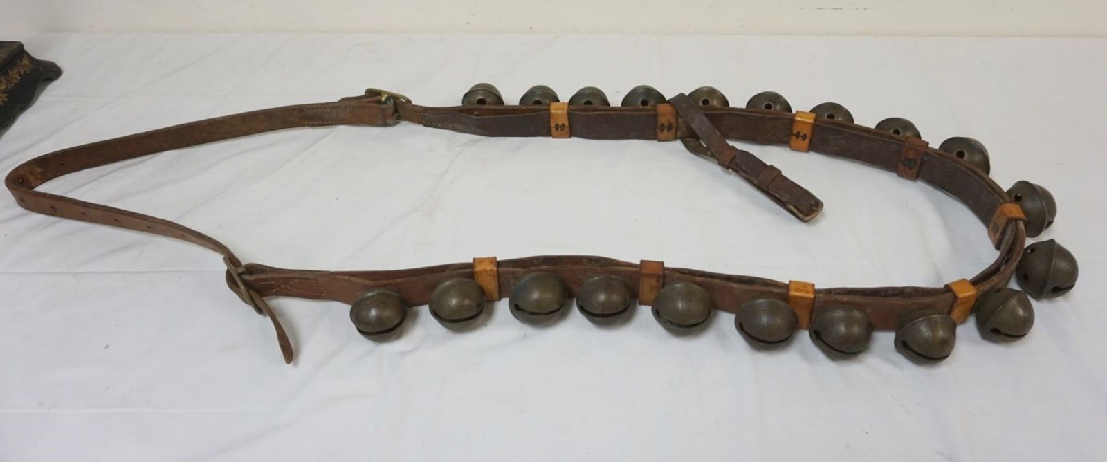 BRASS SLEIGH BELLS: BRASS SLEIGH BELLS, 20 MOUNTED ON LEATHER STRAP, BELLS APPROXIMATELY 2 1/2 IN