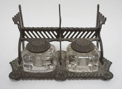 ANTIQUE DOUBLE INKWELL: ANTIQUE DOUBLE INKWELL IN ORNATE CAST METAL STAND W/PEN HOLDERS, APPROXIMATELY 10 IN X 5 IN X 6 IN IGH