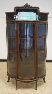 SOLID OAK CURVED GLASS CHINA CABINET: SOLID OAK CURVED GLASS CHINA CABINET WITH CARVED MIRROR BACK GALLERY TOP, NORTH FACE, MIRROR NEEDS RESILVERING, APPROXIMATELY 41 IN X 16 IN X 74 IN H