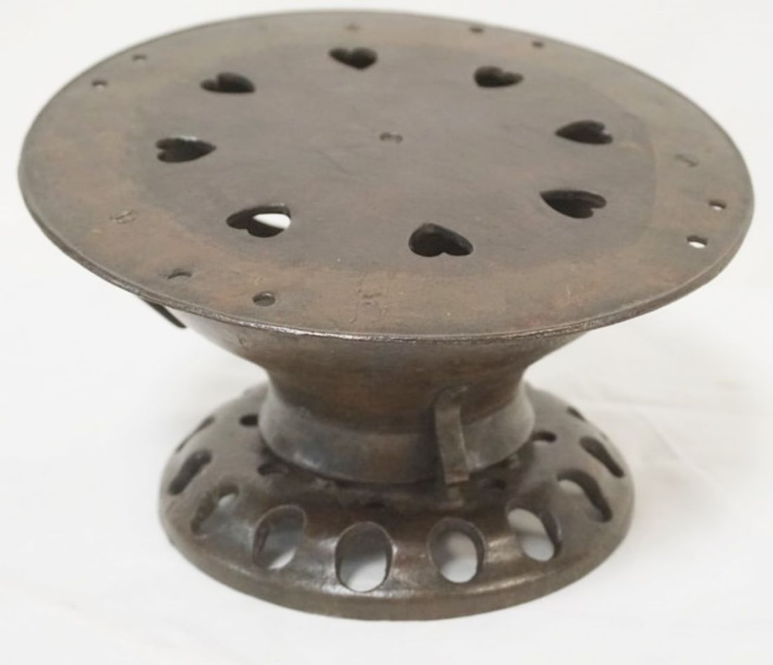 CAST IRON FOOTWARMER: CAST IRON FOOTWARMER W/HEART SHAPE CUT OUTS ON TOP, APPROXIMATELY 10 IN ROUND X 5 1/2 IN HIGH