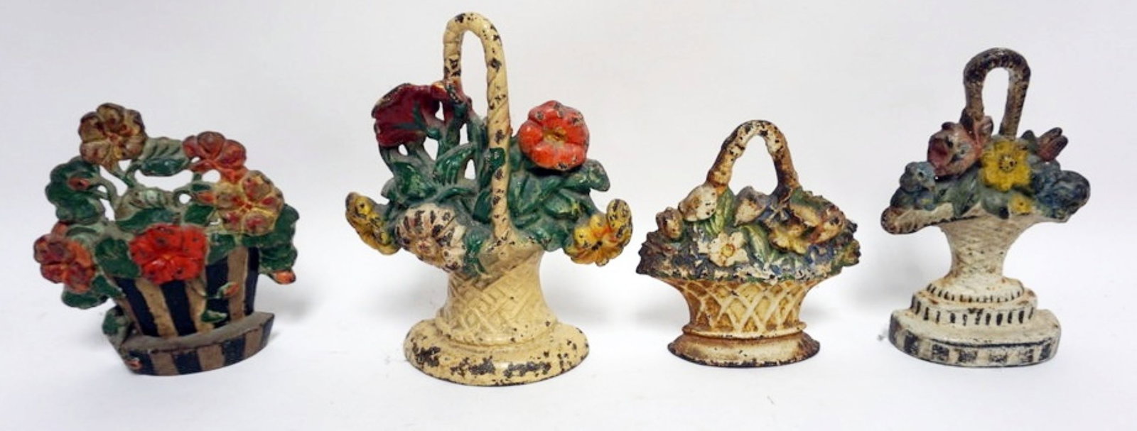 FLOWER BASKET DOOR STOPS: 4 CAST IRON FLOWER BASKET DOOR STOPS, LARGEST APPROXIMATELY 10 IN H