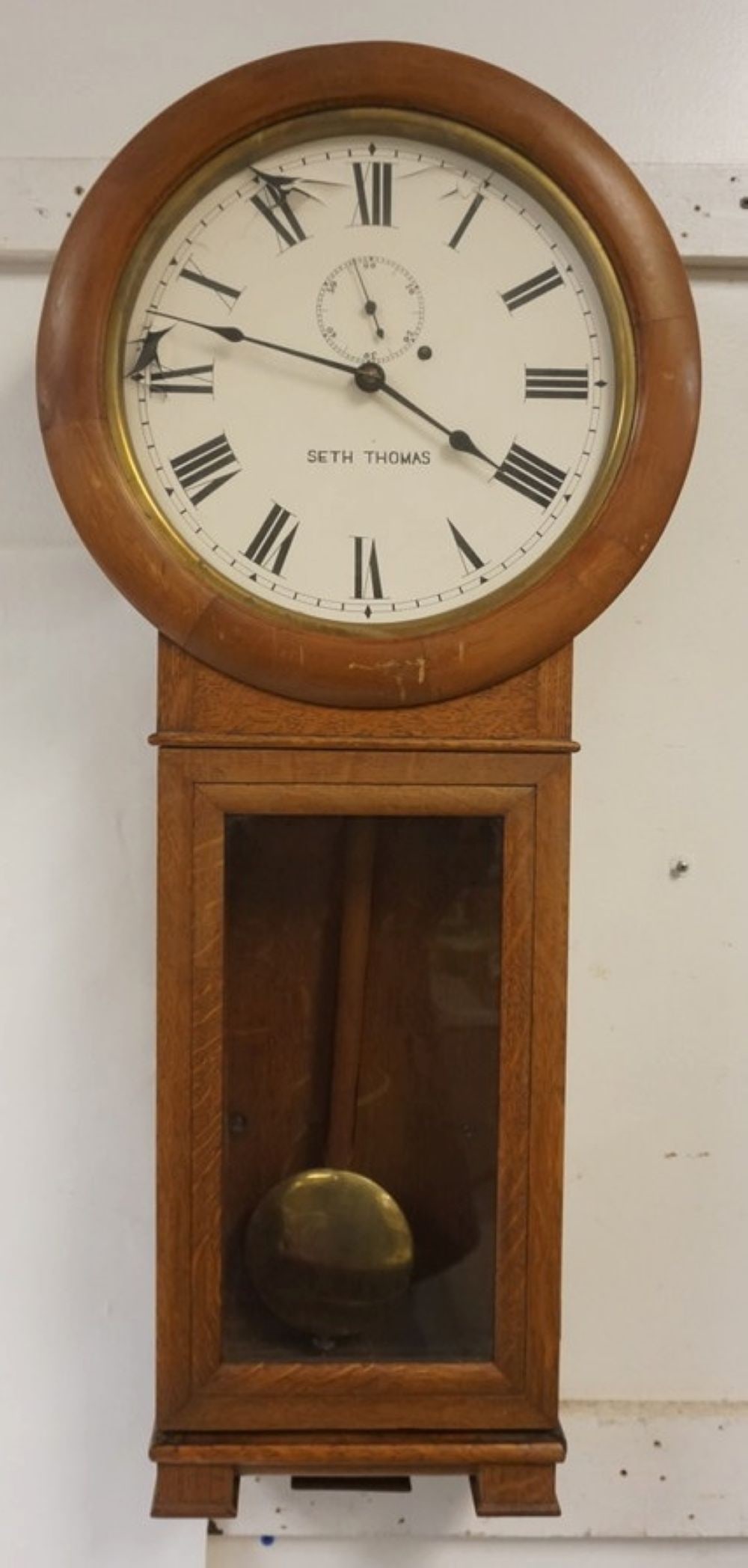 SETH THOMAS WALL CLOCK: SETH THOMAS WALL CLOCK IN OAK CASE, APPROXIMATELY 16 IN X 5 IN X34 IN, LOSS TO FACE