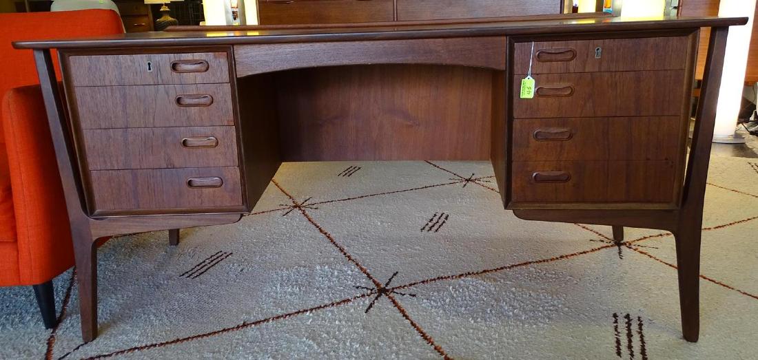 SVEND AAGE MADSEN FOR MOREDDI DANISH MODERN TEAK DESK: FEATURES 9 DRAWERS ON WORKING SIDE WITH STORAGE AND SHELVING ON OPPOSING SIDE. SLIGHTLY CURVED CASE WITH RAISED BACK EDGE. SCULPTURAL LEGS AND INSET PULLS. GOOD CONDITION. WEAR CONSISTENT WITH AGE AND