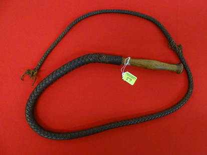 1930'S LEATHER BRAIDED BULL WHIP: SWIVEL AND PINNED HANDLE, HAVING SOME DE-BRAIDING IN THE WHIP.