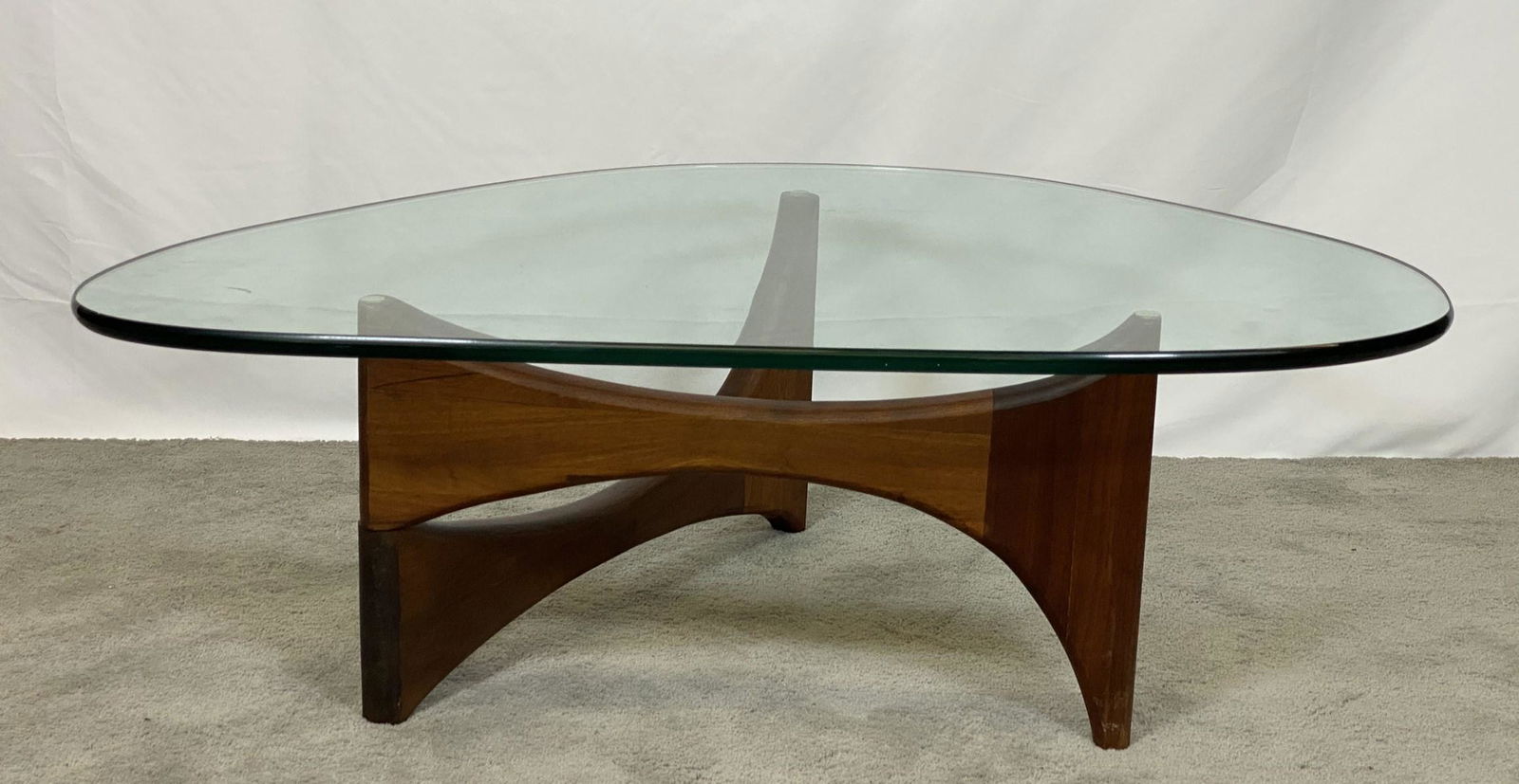 ADRIAN PEARSALL COCKTAIL TABLE: ARTICULATING BASE, HEAVY GLASS TOP, WALNUT BASE.