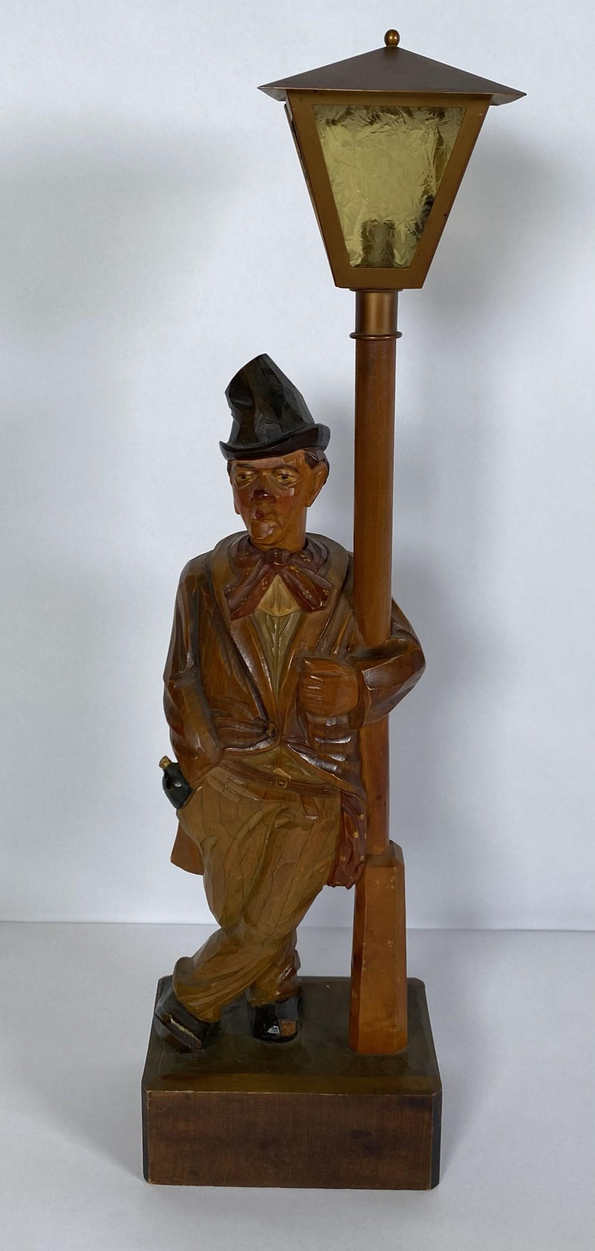 KARL GRIESBAUM (ATTR.) WHISTLER AUTOMATON: CARVED AND PAINT DECORATED MAN LEANING AGAINST A LAMP POST. WINDS AND WHISTLES GREAT. BATTERY OPERATED LAMP (NO BULB). 19.5"H