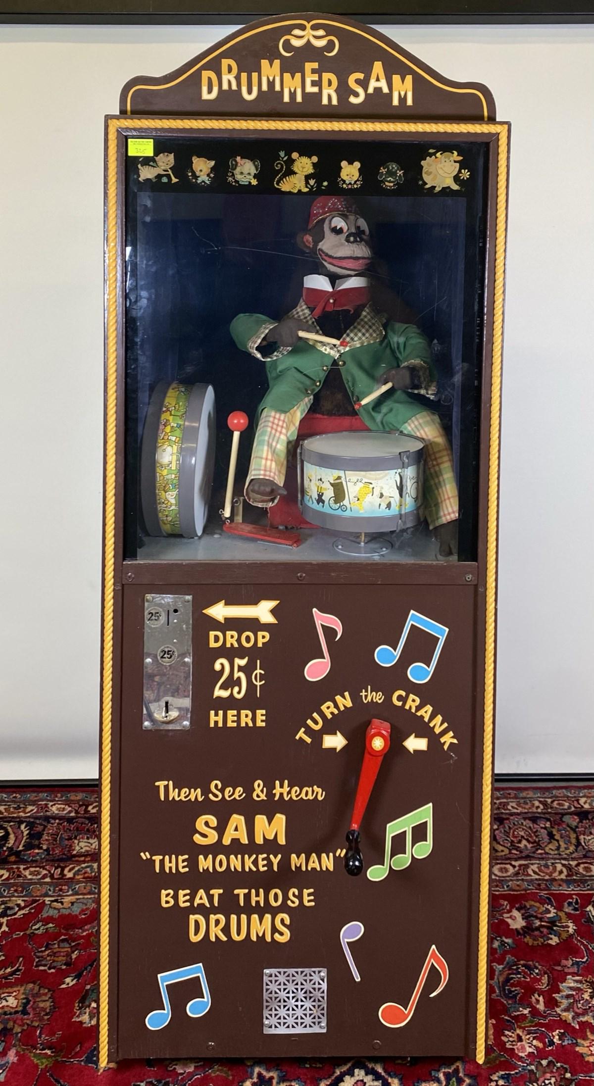 DRUMMER SAM COIN OPERATED MACHINE: 25-CENT MACHINE WITH CRANK THAT ANIMATES DRUMMING MOTION. 70"H, 21"D, 25.5"W