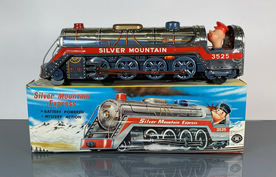 SILVER MOUNTED EXPRESS TIN LITHO LOCOMOTIVE: JAPAN - WITH ORIGINAL BOX. HAVING BATTERY POWER, MYSTERY ACTION, A CLANG-CLANG SOUND, AN ANIMATED ENGINEER, AUTHENTIC TRAIN WHISTLE, FLASHING BOILER.16"X4"X5"