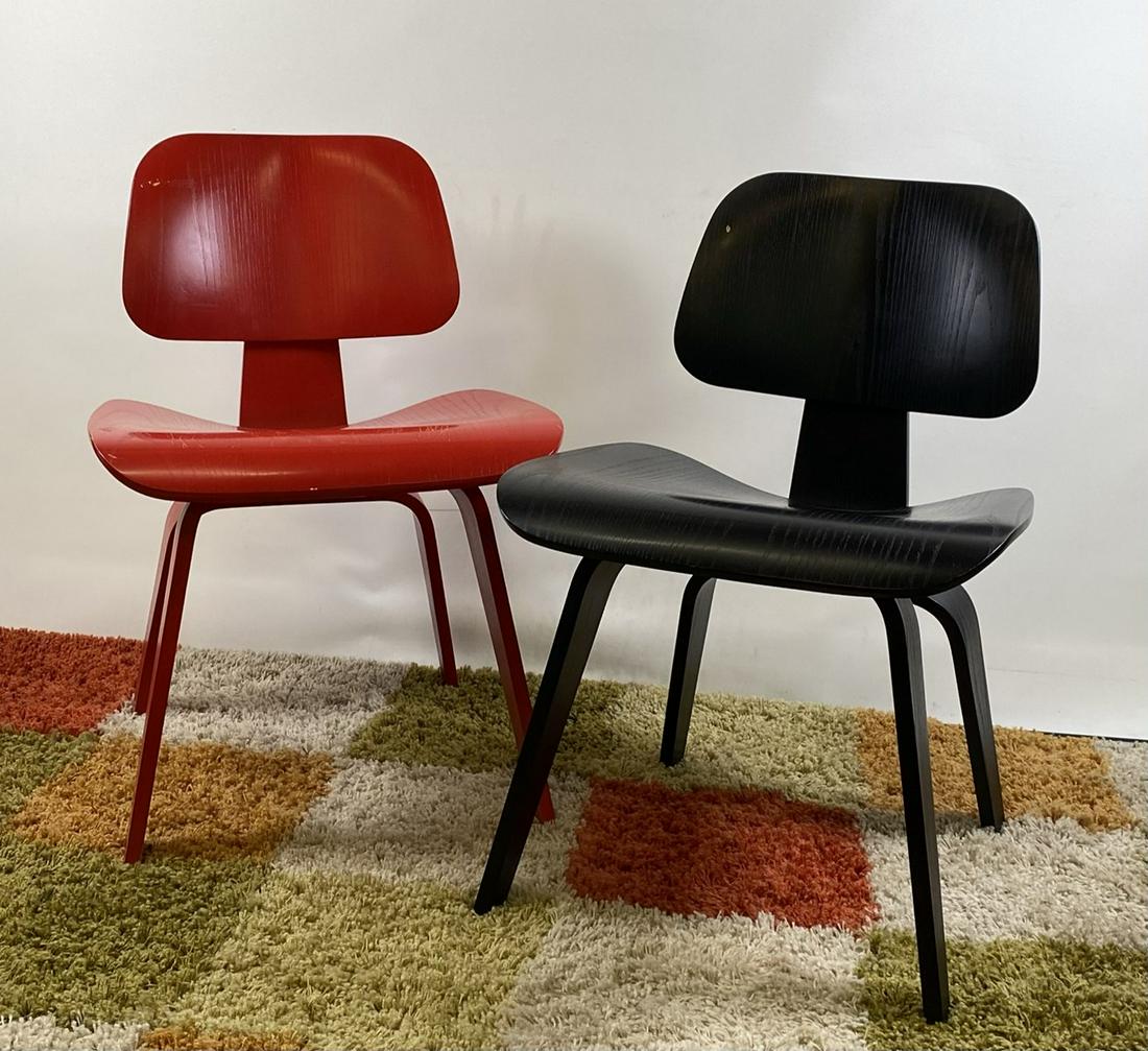 CHARLES AND RAY EAMES DCW CHAIRS: IN RED AND BLACK, BOTH WITH WEAR AND SCUFFS CONSISTENT WITH AGE AND USE.