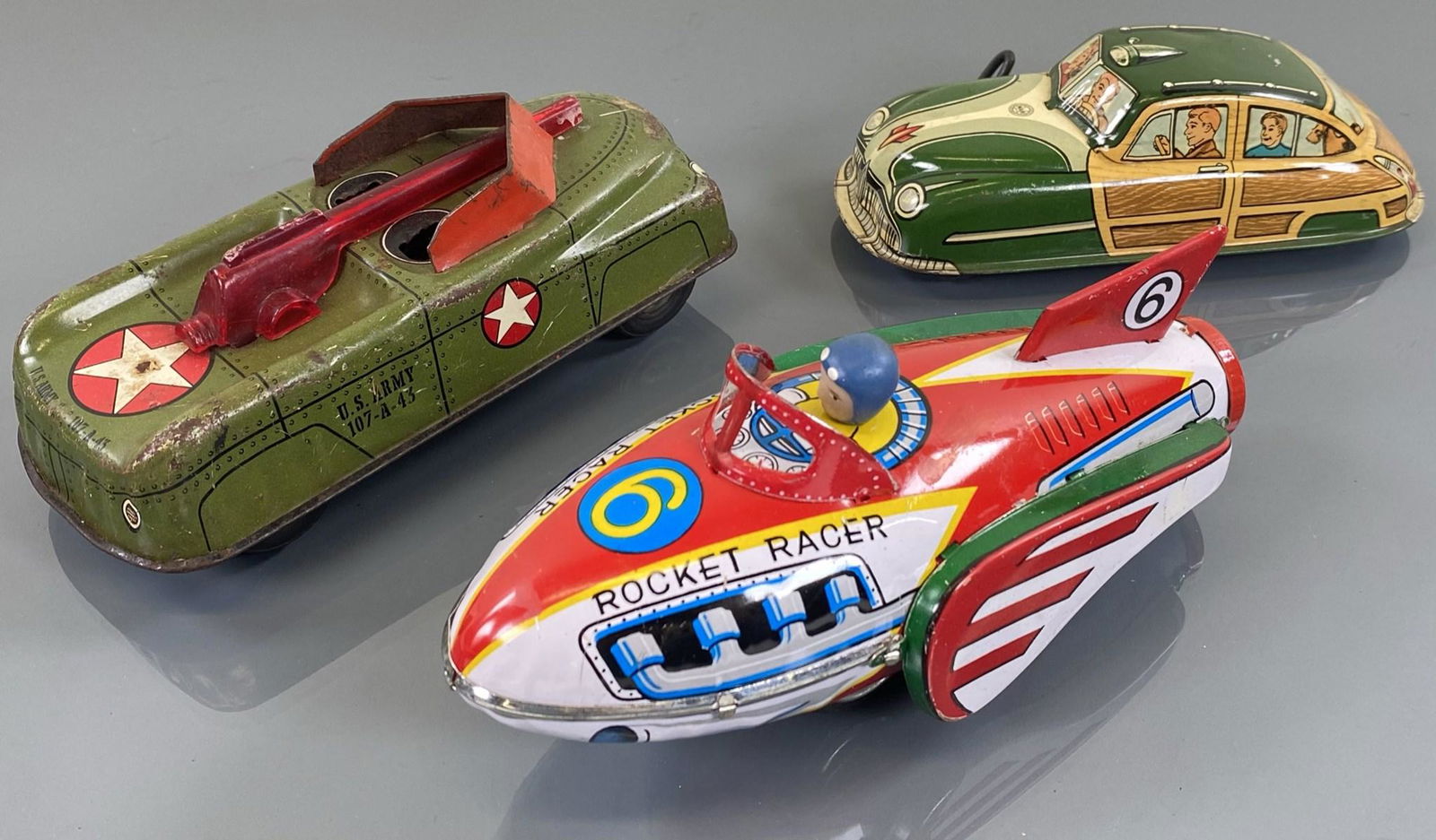 TRIO OF TIN LITHO TOYS: REACH COURTLAND FRICTION TANK, JAPANESE ROCKET RACER, MARX WOODY.