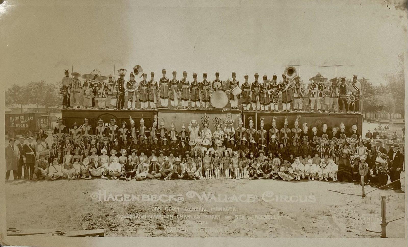 EDWARD J. KELTY (AMERICAN, 20TH C.) PHOTOGRAPH: PAUL WENZEL (CLOWN) COLLECTION. ORIGINAL KELTY PHOTOGRAPH OF THE HAGENBECK WALLACE CIRCUS, C.1933. DEPICTIONS OF THE GEISHA SPEC, CLYDE BEATTY, INDIANS, AND BAND WITH WAGON IN BACK GROUND. 12"X20" WIT