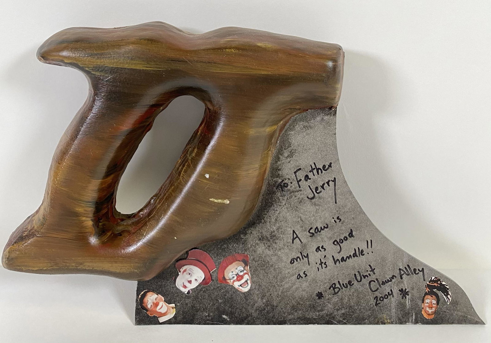 RBBB BLUE UNIT 2004 CLOWN ALLEY PROP: FATHER JERRY HOGAN COLLECTION. A GIFT FROM RBBB CLOWN ALLEY WITH INSCRIPTION, "A SAW IS ONLY AS GOOD AS IT'S HANDLE!!!"