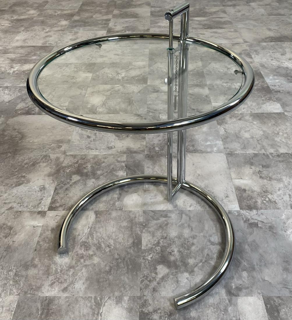 EILEEN GRAY ADJUSTING SIDE TABLE: CHROME STRUCTURE WITH GLASS TOP.