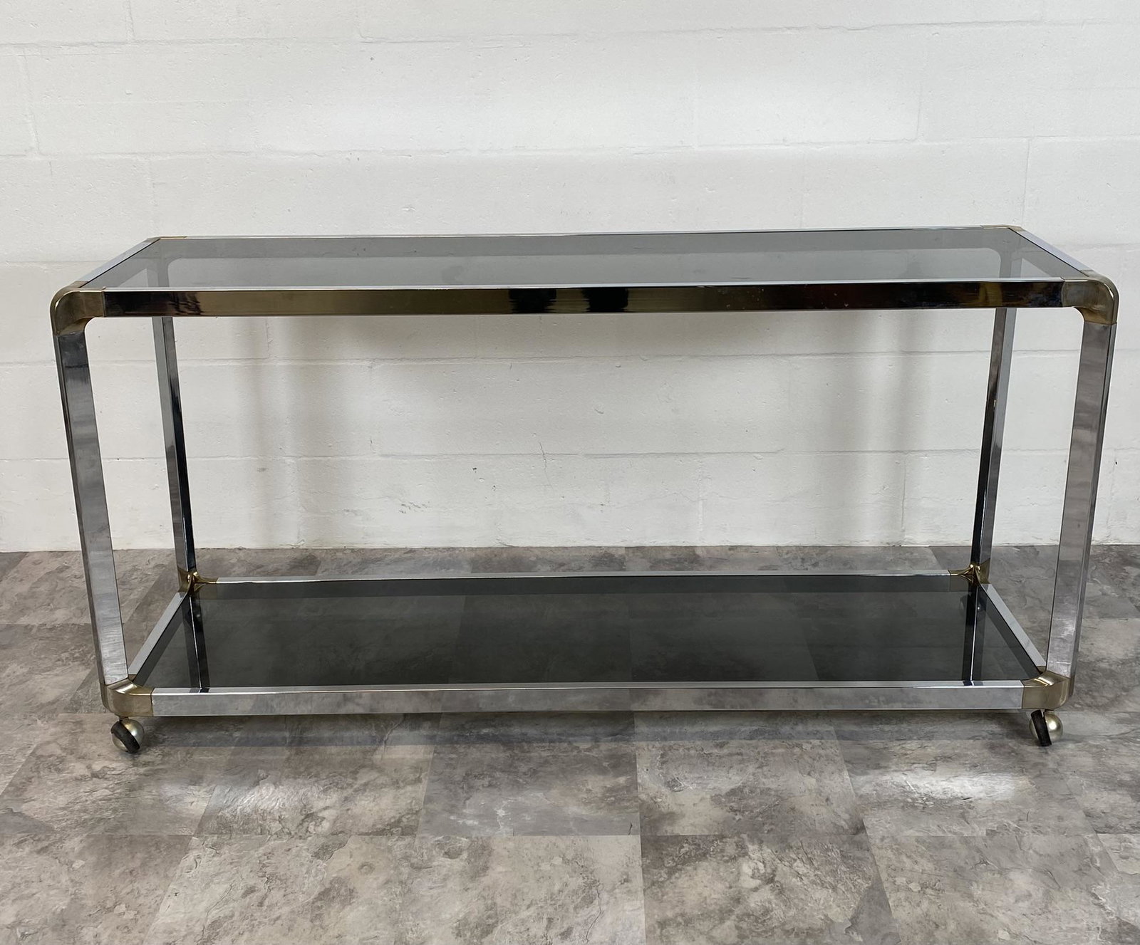 ROLLING CONSOLE TABLE/SERVER: CHROME ACCENTED WITH BRASS CORNERS. SMOKED GLASS. 56W, 16D, 28D