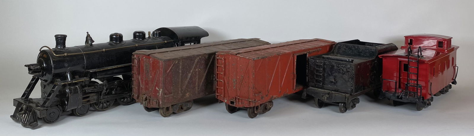 BUDDY L OUTDOOR TRAIN WITH TENDER AND CATTLE CARS AND CABOOSE: ORIGINAL CONDITION BUDDY L OUTDOOR TRAIN WITH TENDER. SOME CHIPPED STICKERS REMAINING. ENGINE HAS BLACK PAINT ENHANCEMENT. ORIGINAL CATTLE CARS, ONE IN GOOD USED AND THE OTHER, CORRODED ORIGINAL. MOST